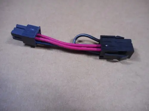 Stecker mit zwei Anschlüssen und drei Drähten in rot und schwarz, geeignet als Brückenstecker. Hergestellt von der Marke Remeha.